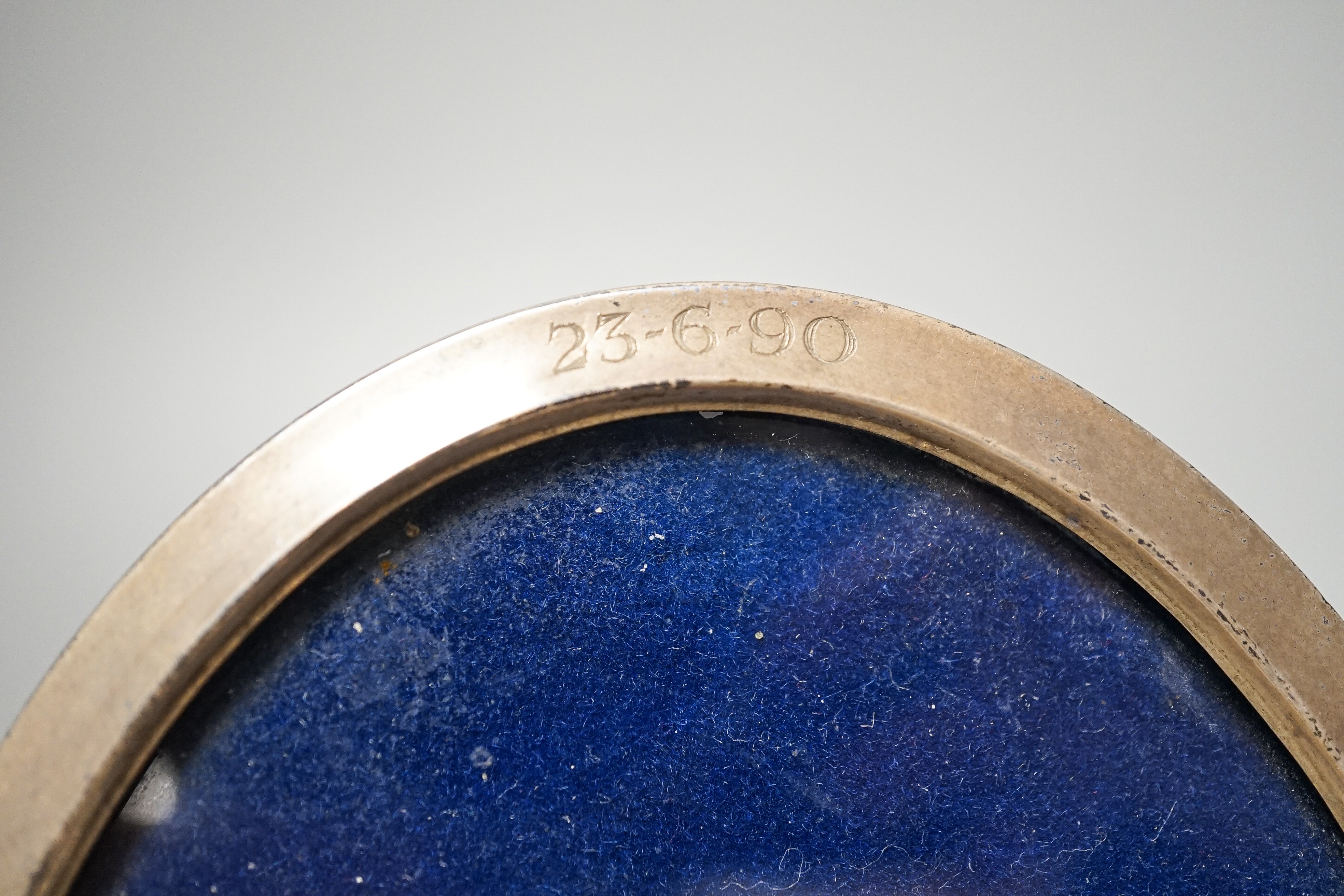 A pair of modern silver mounted wine coasters, W.E.V. London, 1990, (a.f.), 12.2cm and a 925 mounted oval photograph frame.
